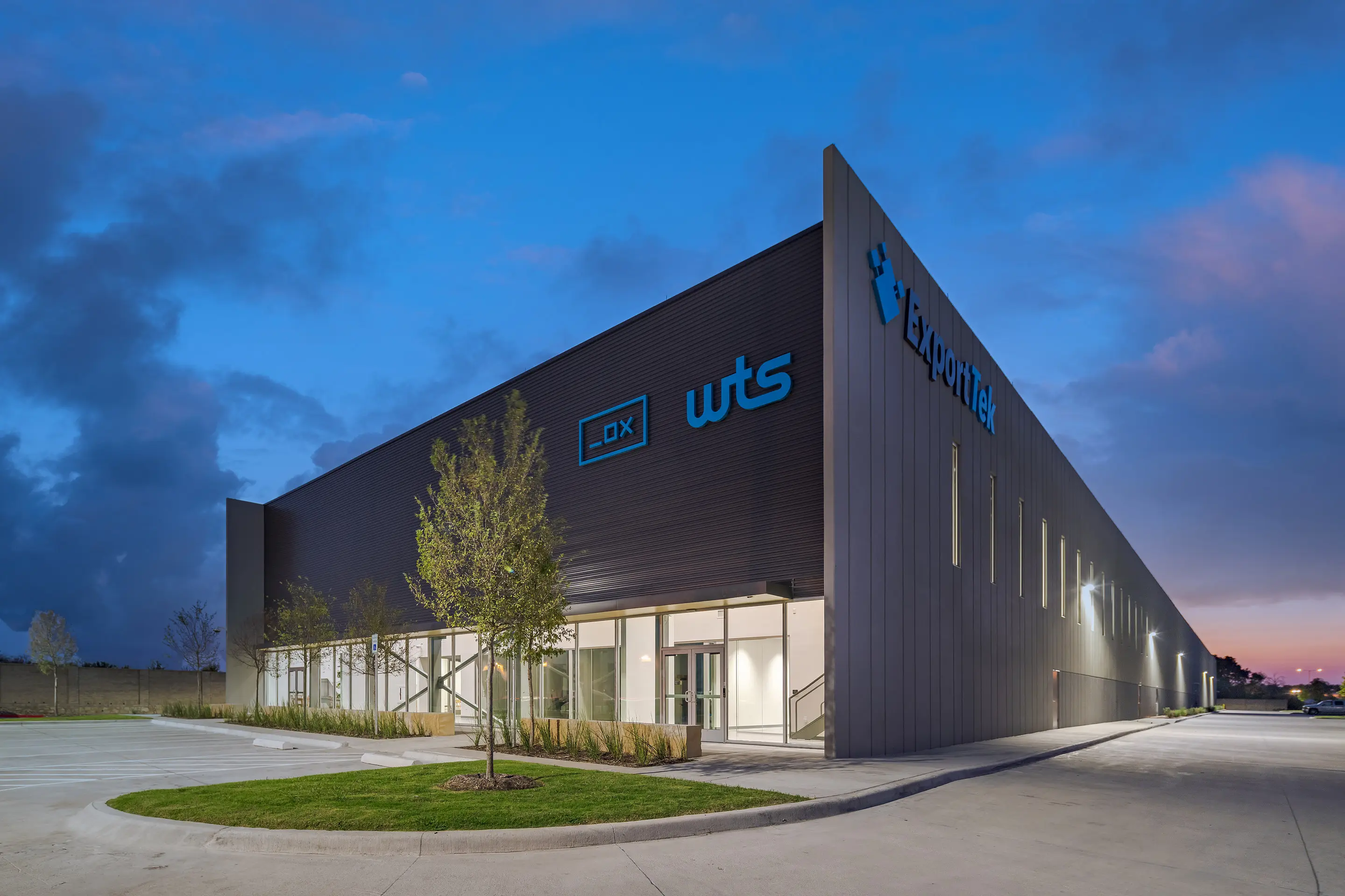 The WesternTechSystems facility in Lewisville, Texas at night, with the illuminated company signage